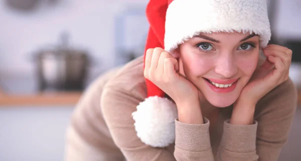 Χαμογελαστή νεαρή γυναίκα στην κουζίνα, απομονωμένη στο φόντο των Χριστουγέννων — Φωτογραφία Αρχείου