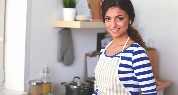 Jeune femme coupant des légumes dans la cuisine — Photo