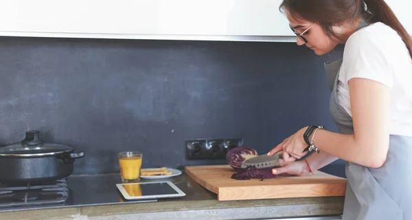 Junge Frau kocht mit Tablet-Computer in ihrer Küche — Stockfoto