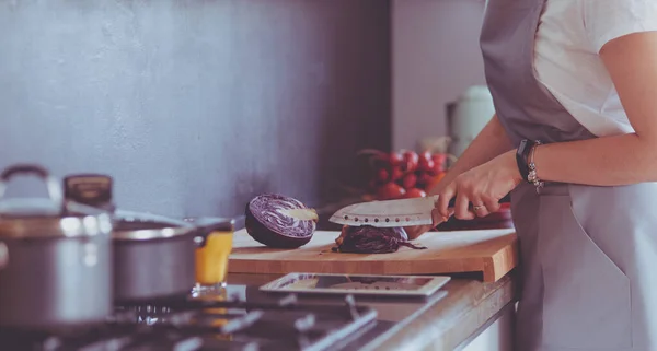 Yeni mutfakta yemek pişiren kadın sebzelerle sağlıklı yemekler yapıyor. — Stok fotoğraf