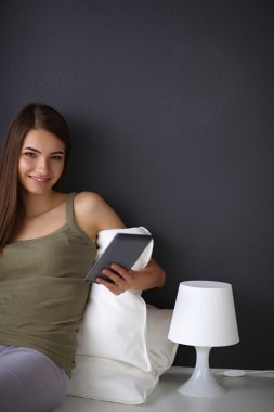 bir yastık ve uçak tablo ile katta oturan güzel esmer kadın