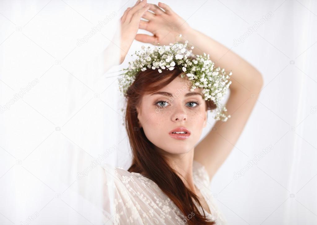Portrait of a beautiful blonde woman with flowers in her hair