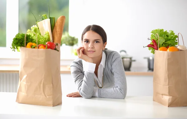 Portrait of a smiling woman cooking in her kitchen sitting — Stock Photo, Image