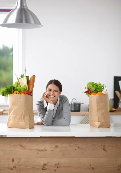 Portrait of a smiling woman cooking in her kitchen sitting — Stock Photo, Image