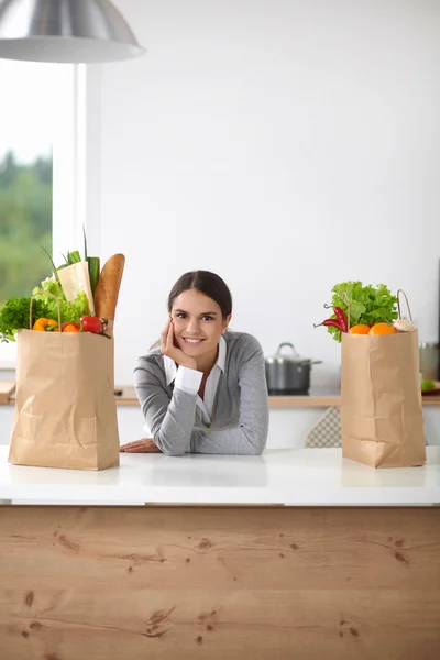 Portrait of a smiling woman cooking in her kitchen sitting — Stock Photo, Image