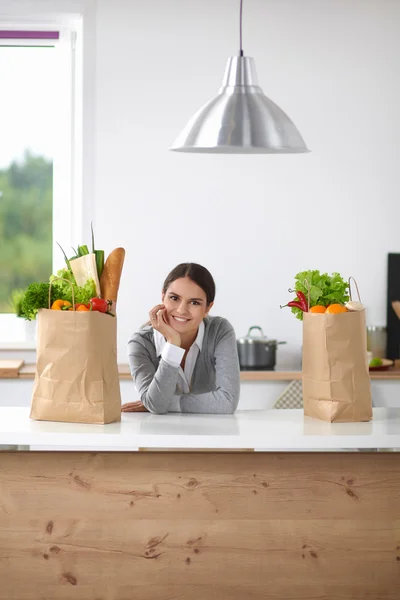 Portrait of a smiling woman cooking in her kitchen sitting — Stock Photo, Image