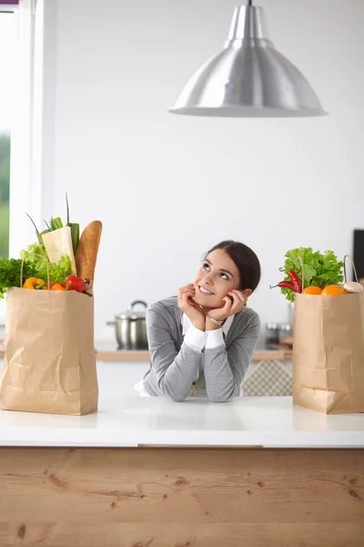 Portrait of a smiling woman cooking in her kitchen sitting — Stock Photo, Image