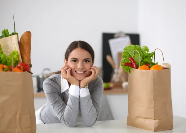 Porträtt av en leende kvinna som lagar mat i köket sittande — Stockfoto