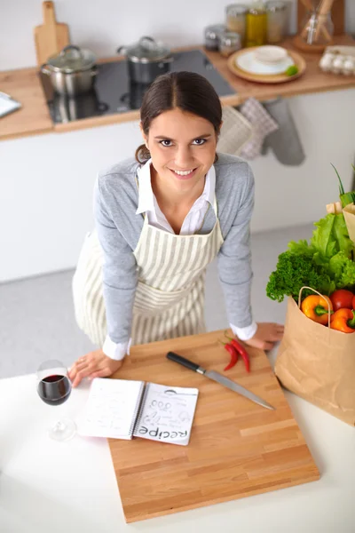 Vrouw maken van gezonde voeding staande glimlachend in keuken — Stockfoto