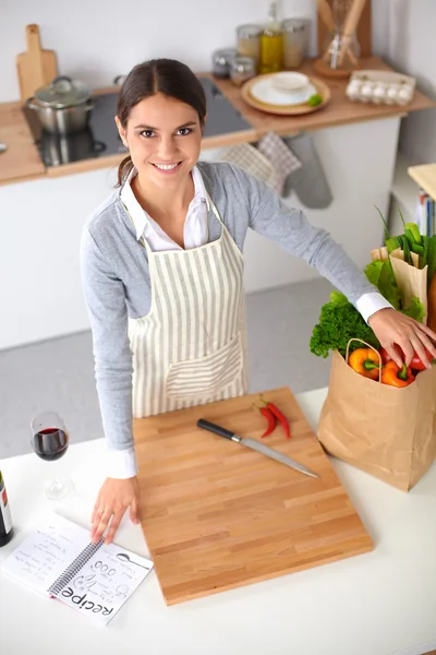 Mujer haciendo comida saludable de pie sonriendo en la cocina — Foto de Stock