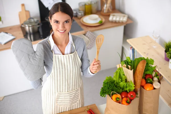 Mujer haciendo comida saludable de pie sonriendo en la cocina —  Fotos de Stock
