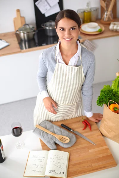 Vrouw maken van gezonde voeding staande glimlachend in keuken — Stockfoto