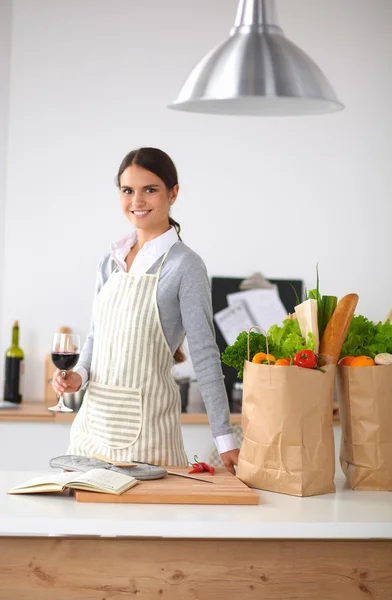 Vrouw met boodschappentassen in de keuken thuis, bij het bureau — Stockfoto
