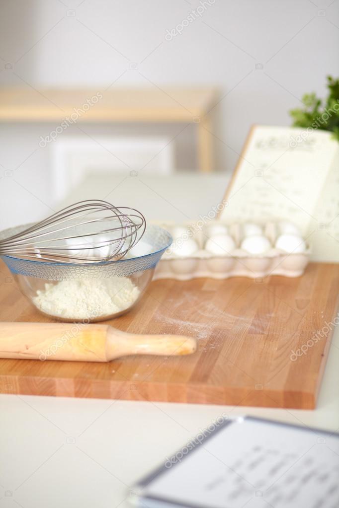 Flour with eggs, ricotta cheese and rolling pin at the desk