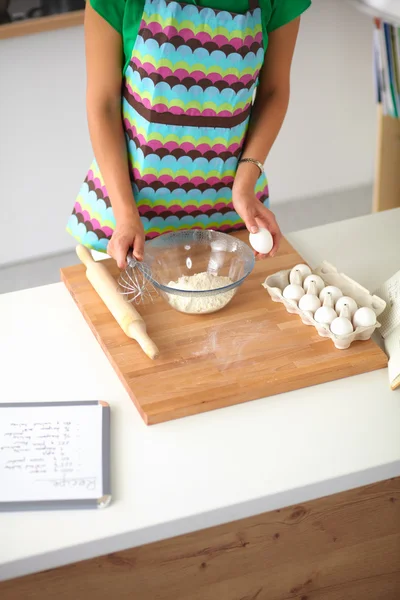 Mujer joven sonriente en la cocina, aislada en el fondo — Foto de Stock