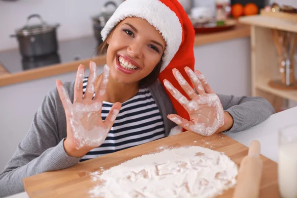 幸せな若い女性笑顔幸せを持って楽しみますクリスマスの準備を身に着けているサンタの帽子 — ストック写真