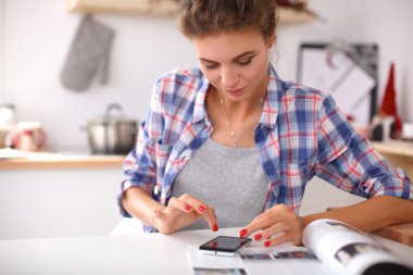 Mutfakta Mgazine okuyan bir kadın.