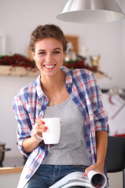 Mutfakta Mgazine okuyan bir kadın.