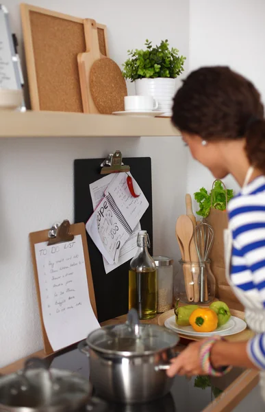 Mooie vrouw staande in keuken met schort — Stockfoto