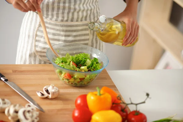 Mujer joven sonriente mezclando ensalada fresca —  Fotos de Stock