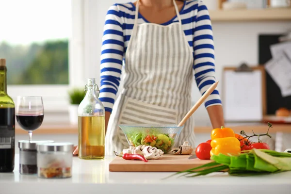 Glimlachende jonge vrouw mengen van verse salade — Stockfoto