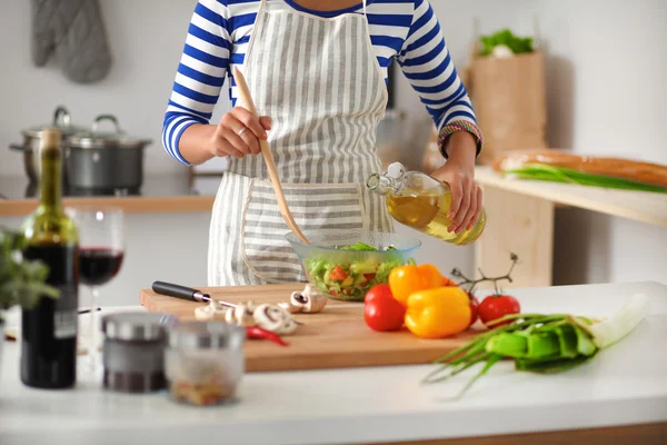 Glimlachende jonge vrouw mengen van verse salade — Stockfoto