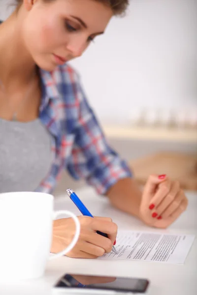 Junge Frau schreibt etwas in ihren Notizblock — Stockfoto