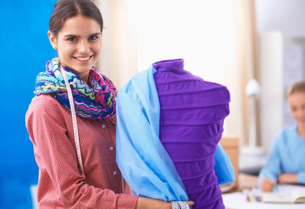 Smiling fashion designer standing near mannequin in office — Stock Photo, Image