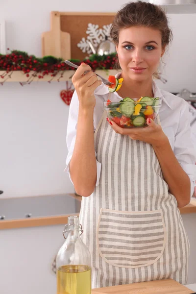 Giovane donna mangiare insalata fresca in cucina moderna — Foto Stock