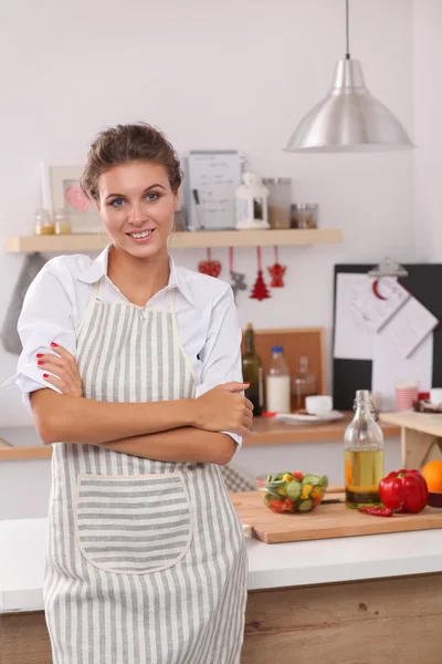 Smiling young woman in the kitchen, isolated on christmas background — Stock Photo, Image