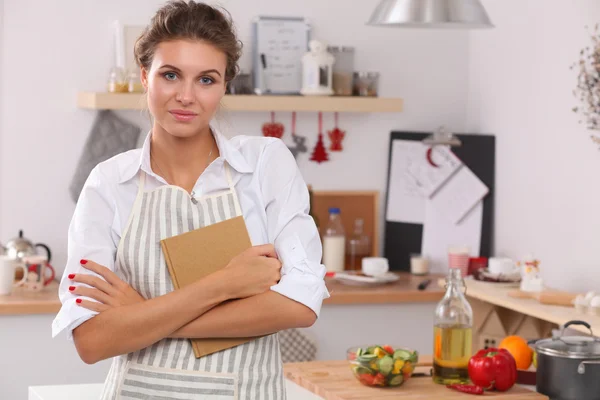 Mujer joven sonriente en la cocina, aislada en el fondo de Navidad —  Fotos de Stock