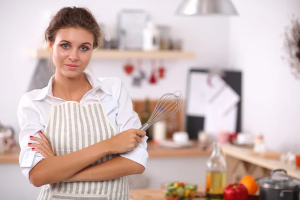 Женщина с короллой стоит на кухне — стоковое фото