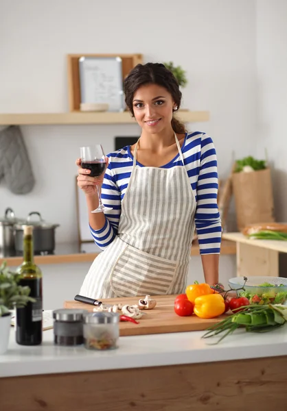 Mujer joven cortando verduras en la cocina — Foto de Stock