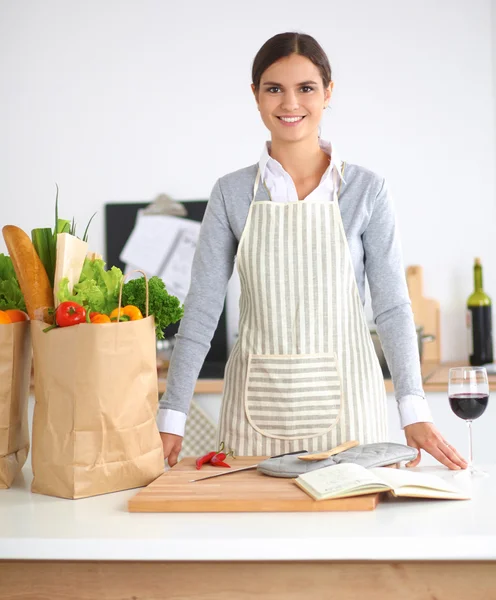 Mujer con bolsas de compras en la cocina en casa, de pie cerca —  Fotos de Stock