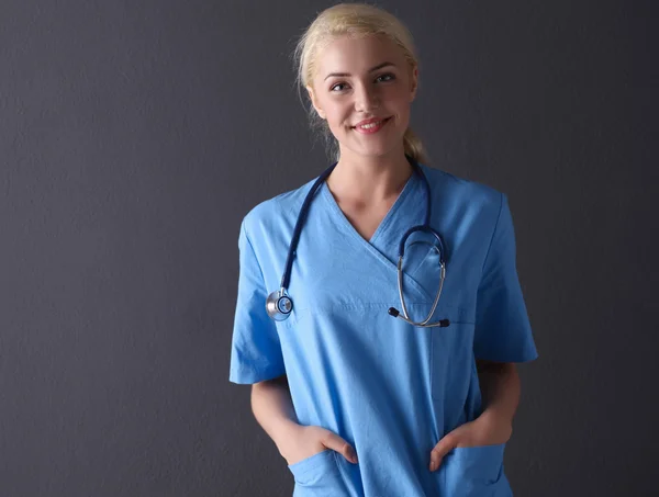 Ung läkare kvinna med stetoskop isolerad på grå — Stockfoto