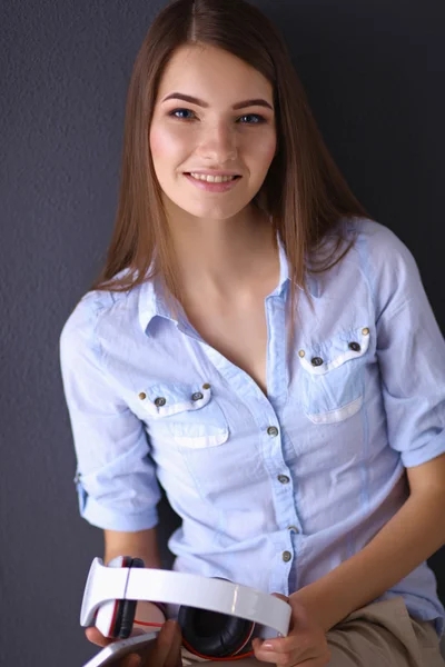 Smiling girl with headphones sitting on the floor — Stock Photo, Image