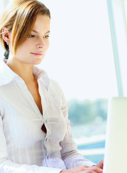 Happy businesswoman working on laptop
