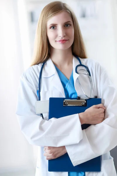 Retrato de médico mulher com pasta no corredor do hospital — Fotografia de Stock