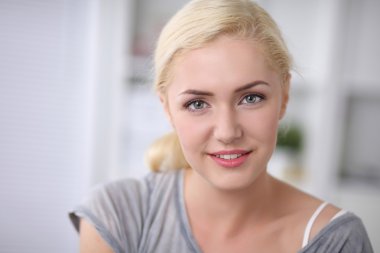 Genç güleryüzlü güzel kadın kanepede onun odasında oturuyordu