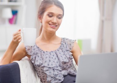 dizüstü bilgisayar ve kahve kanepe genç gülümseyen güzel.