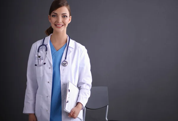 Jeune médecin ou médecin avec presse-papiers et stéthoscope isolé sur fond gris — Photo