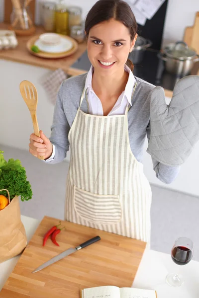 Γυναίκα που κάνει υγιεινά τρόφιμα στέκεται χαμογελώντας στην κουζίνα — Φωτογραφία Αρχείου