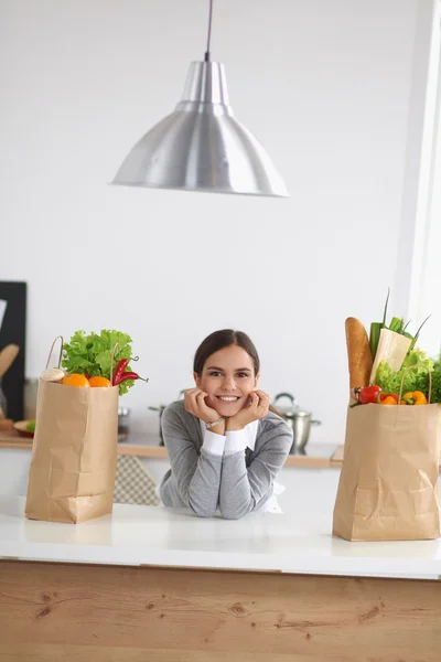 Portrait of a smiling woman cooking in her kitchen sitting — Stock Photo, Image