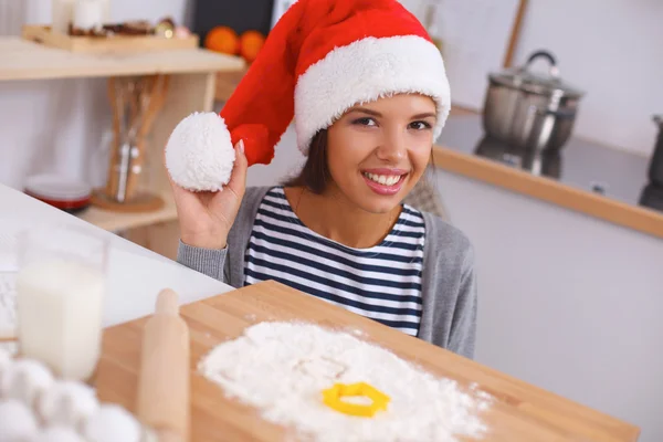 Mutlu genç bayan gülümsüyor Noel hazırlıklarıyla eğleniyor Noel Baba şapkası takıyor. — Stok fotoğraf