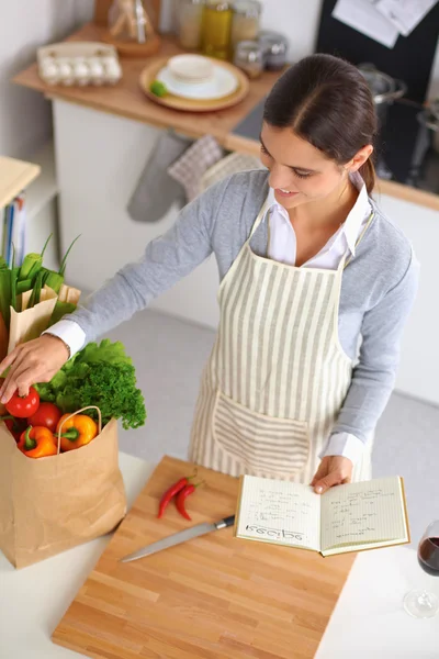 Vrouw maken van gezonde voeding staande glimlachend in keuken — Stockfoto