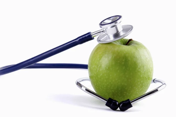 Stetoskop i zielone jabłko izolowane na białym tle , — Zdjęcie stockowe