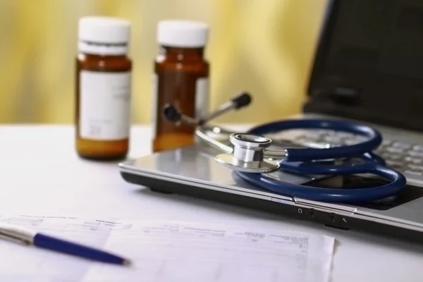 Laptop, stethoscope,bottle of pills, rx on the desk. — Stock Photo, Image