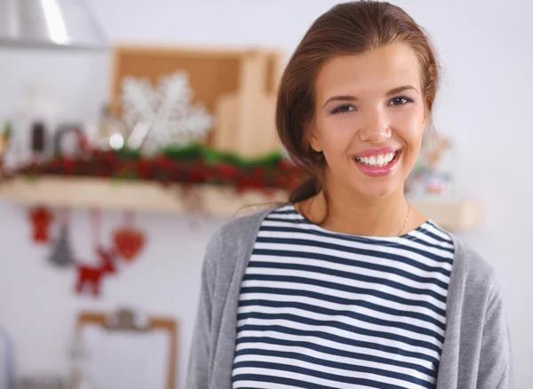 Sorrindo jovem na cozinha, isolado no fundo de Natal — Fotografia de Stock