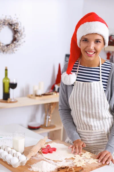 Šťastná mladá žena usmívá šťastný baví s vánoční přípravy na sobě Santa klobouk — Stock fotografie