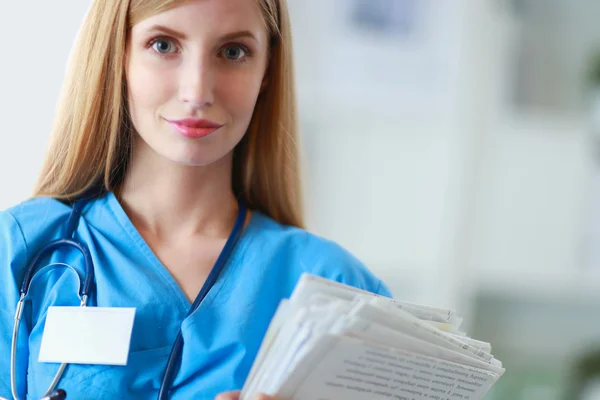 Retrato de médico mulher com pasta no corredor do hospital — Fotografia de Stock